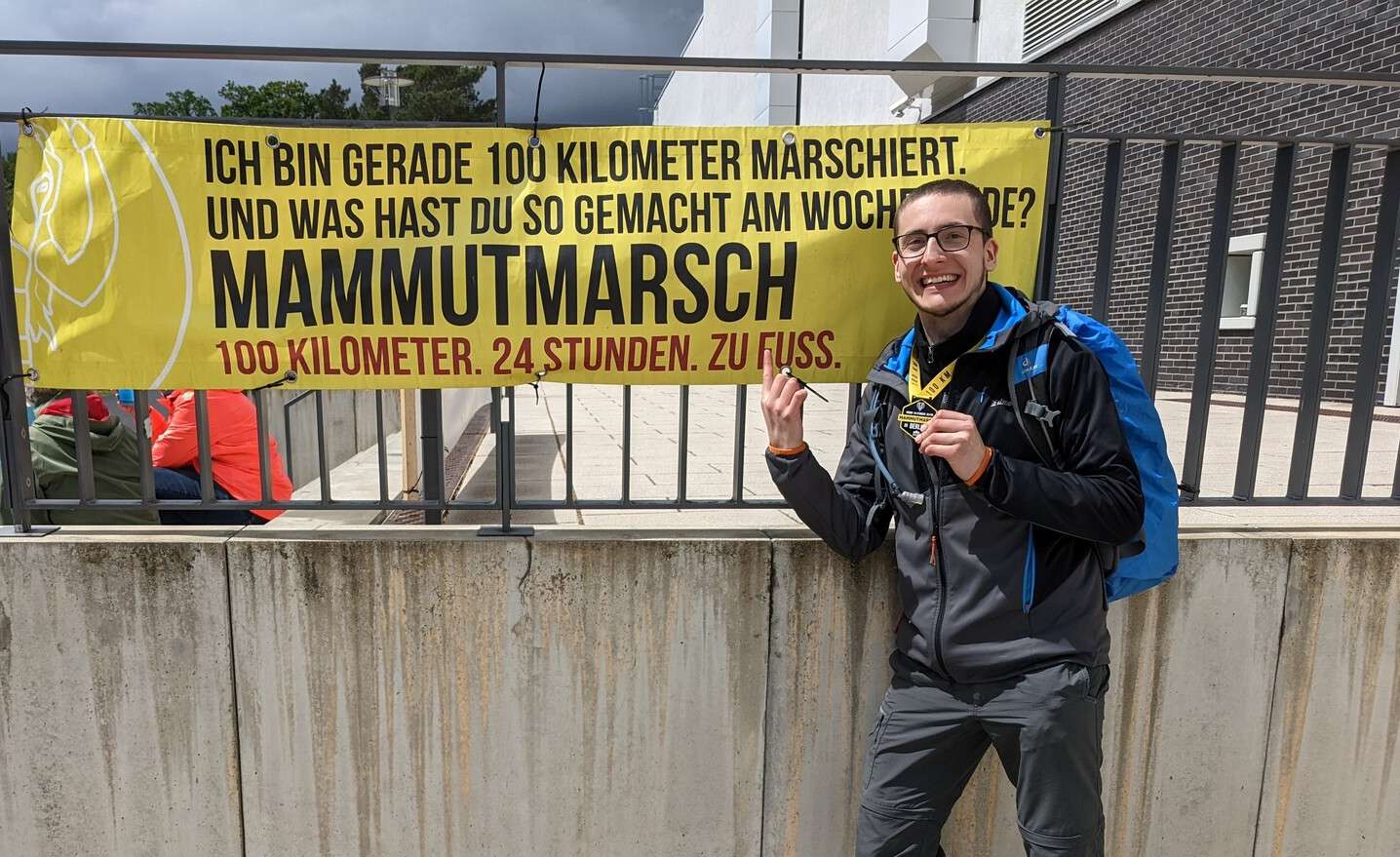 Ich vor einem Mammutmarsch-Banner